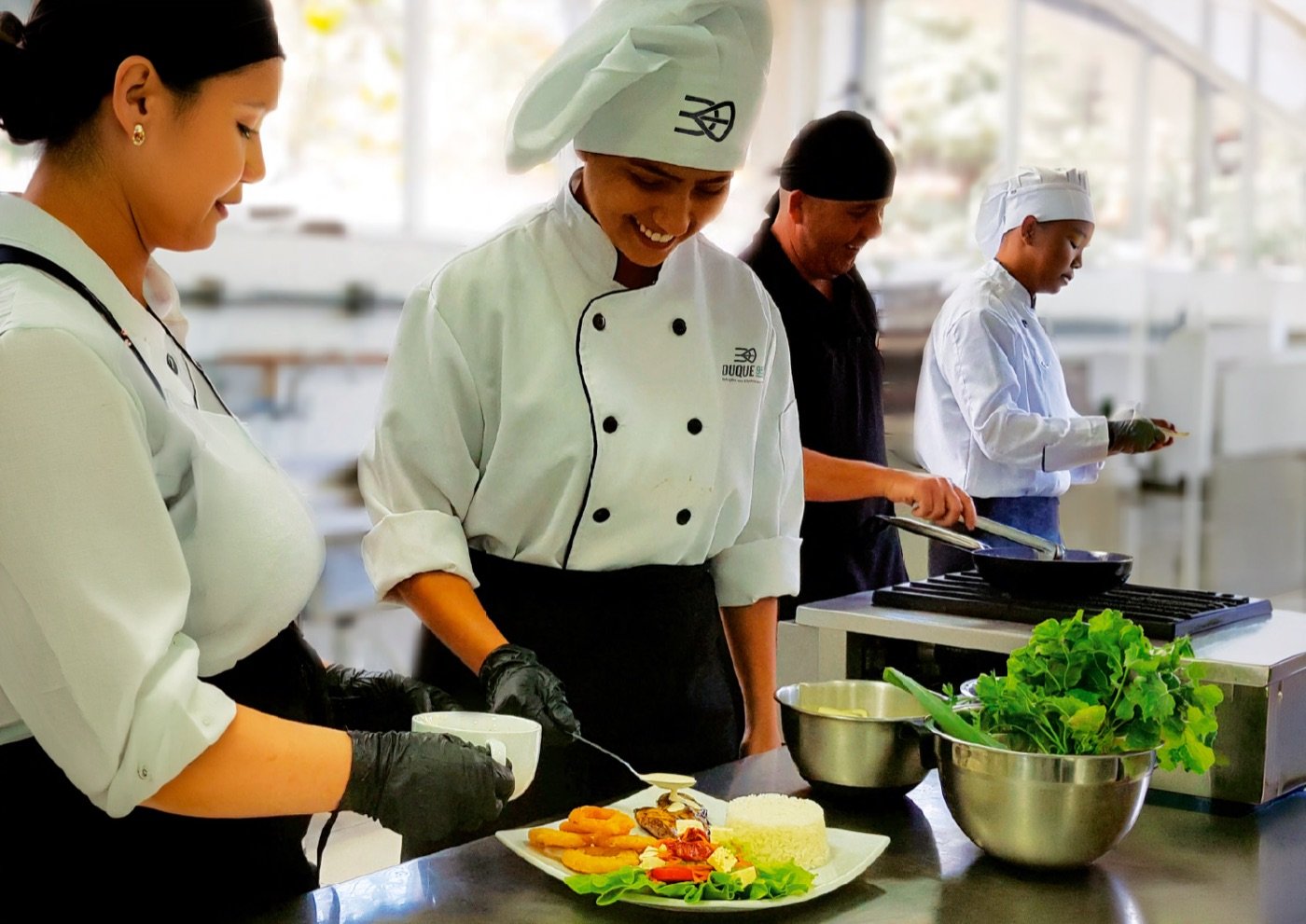 Equipe de chefs da Duque95 finalizando pratos na cozinha central